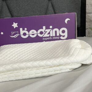 A bed with a purple bedzing sign on it