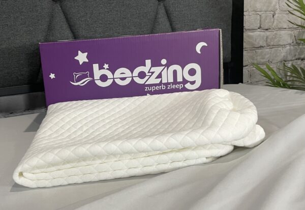 A bed with a purple bedzing sign on it